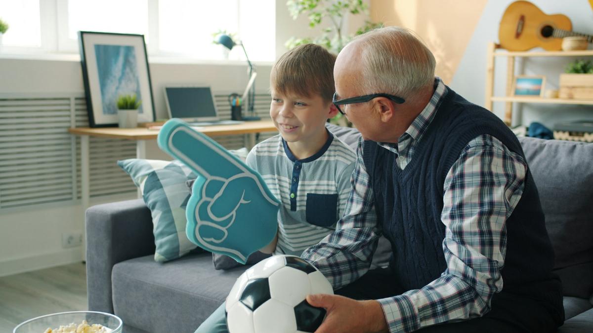 Grandfather and grandson cheering a match